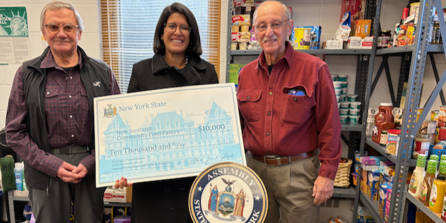 Ivan Gotham (L) NS Community Food Pantry Executive Director, and Dennis Ulion (R) Treasurer, receive a check from Assemblymember Gabriella Romero.